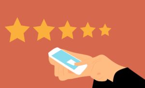 An image of a person giving a 5 star review on their phone