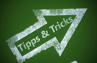 A chalkboard with an arrow that says tips and tricks on it